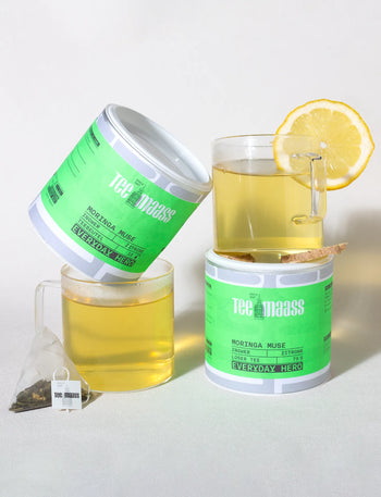 Tee Maass Moringa Muse loser Grüntee in Dose mit frisch aufgebrühtem Tee und Zitrone und Pyramiden-Teebeutel